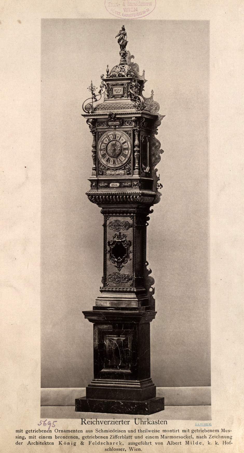Reichverzierter Uhrenkasten mit getriebenen Ornamenten aus Schmiedeeisen und teilweise montiert mit getriebenem Messing, mit einem bronzenen getriebenen Ziffernblatt und einem Marmorblock